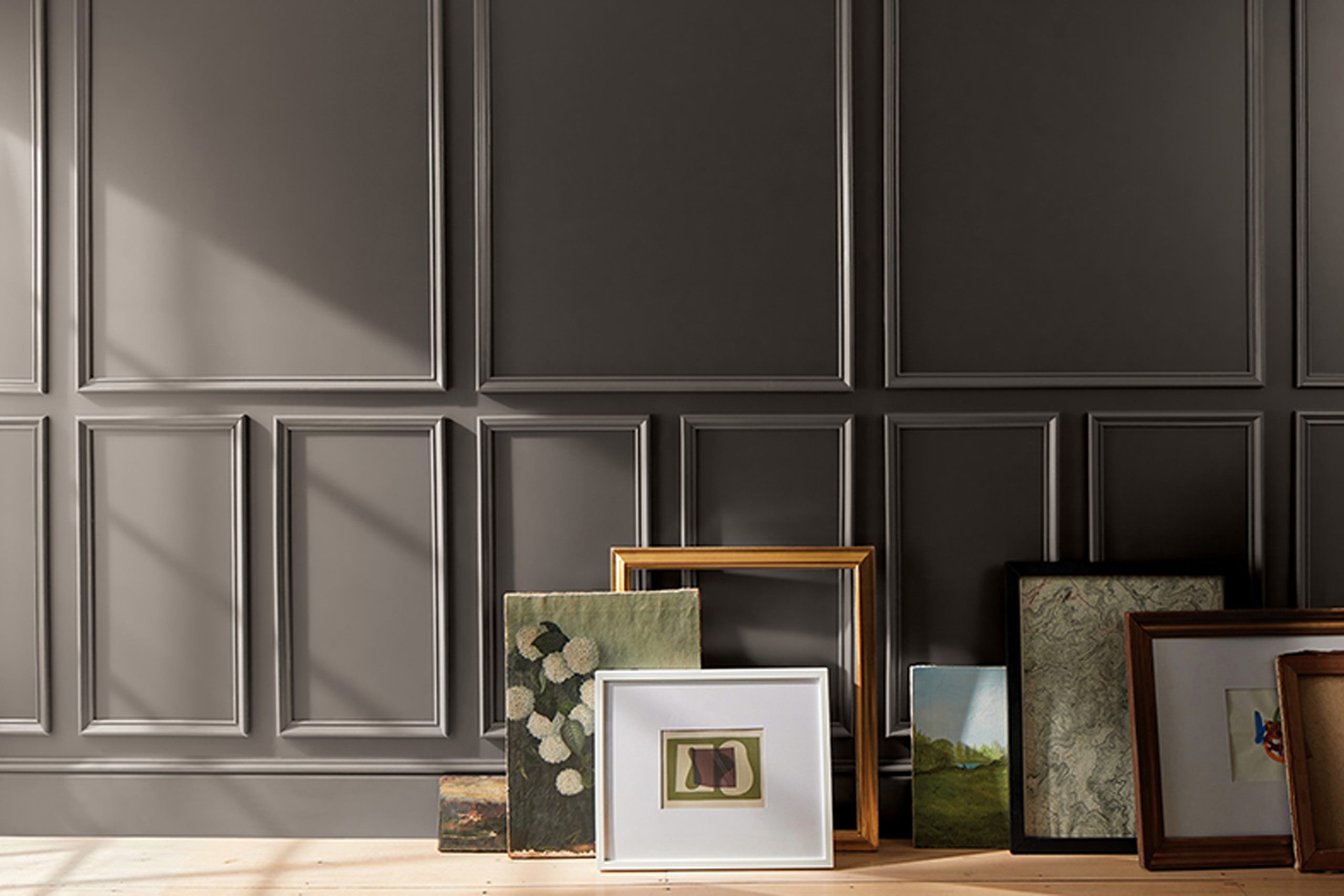 Artwork leaning against a wall painted with Benjamin Moore’s 2026 Color of the Year, Silhouette AF-655