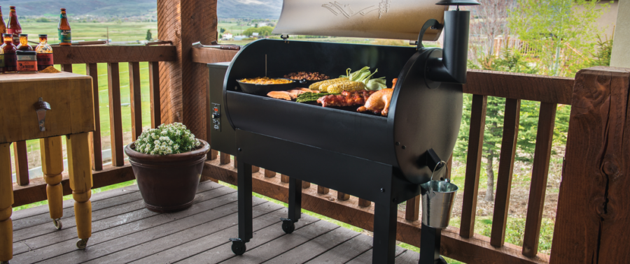 Traeger smoker stationed on deck with vast fields behind it.